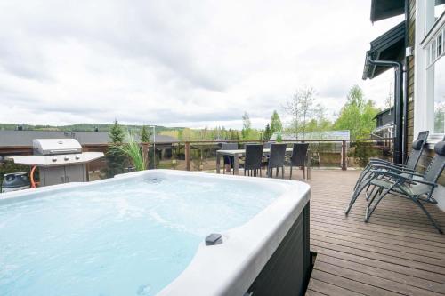 a hot tub on a deck with a table and chairs at Villa Peso 1&2 - 21 hlö, Both sides, HimosYkkösen alue in Jämsä