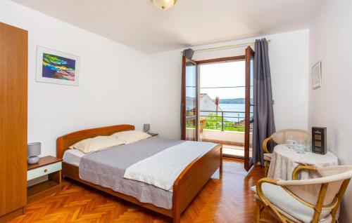 ein Schlafzimmer mit einem Bett und einem Tisch und einem Fenster in der Unterkunft Holiday home Villa Blue coast by Villas Guide in Jadranovo