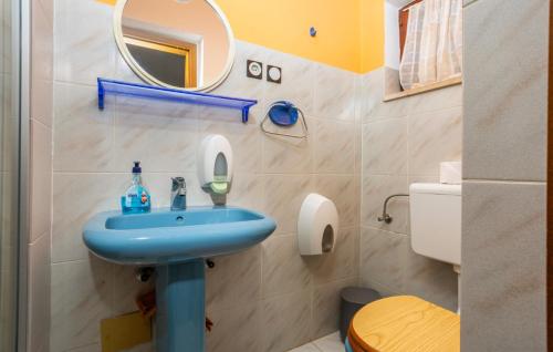 ein Badezimmer mit einem blauen Waschbecken und einem Spiegel in der Unterkunft Holiday home Villa Blue coast by Villas Guide in Jadranovo