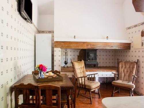 a room with a table and two chairs and a fireplace at Farmhouse Dreams Explore and Relax in Montemor-o-Novo