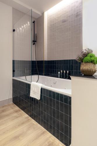 a bathroom with a tub and a glass shower at Meliá Milano in Milan
