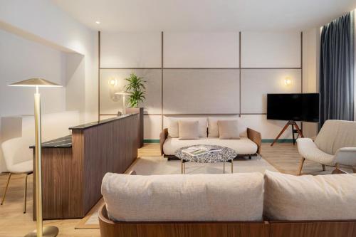 a living room with a couch and a tv at Meliá Milano in Milan