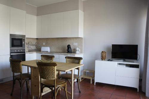 een keuken met een tafel en stoelen en een televisie bij Apartamento Monte Estoril in Cascais
