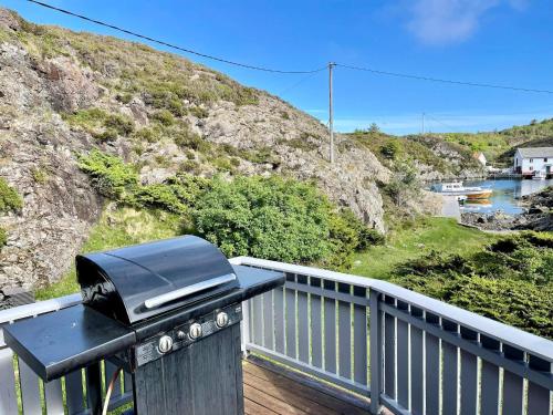 een grill op het balkon van een huis met een heuvel bij 6 person holiday home in Espevær-By Traum in Espevær