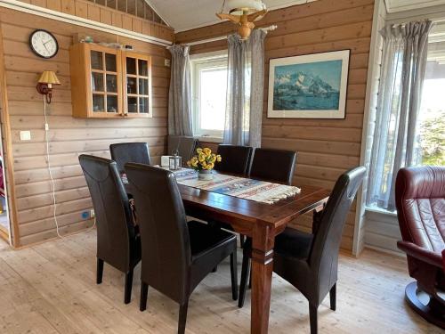 a dining room with a wooden table and chairs at 4 star holiday home in Espevær in Espevær