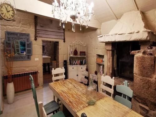 a dining room with a table and chairs and a clock at Villa in A Lama near Rías Baixas Beaches in A Lama