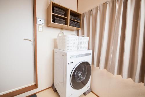 a washing machine in a room with a window at ゆるりたび in Toyama