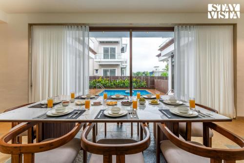 a dining room with a large table and chairs at StayVista at Villa Alora with Jacuzzi in Lonavala