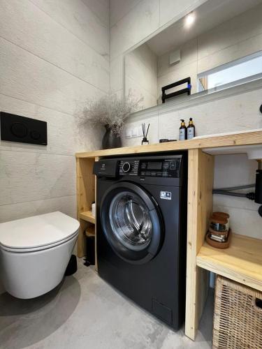 a bathroom with a washing machine and a toilet at Yama Krywe in Krywe