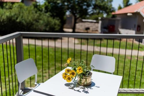a table with a vase of sunflowers on a fence at Ein Zivan Village Resort in Ein Zivan