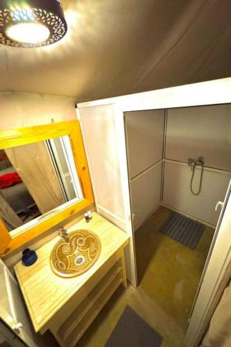 a small bathroom with a sink and a shower at Overnight Sahara Camp in Merzouga