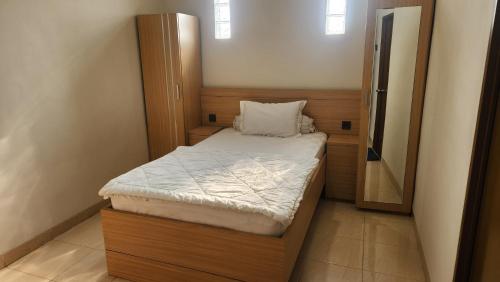 a small bed in a small room with a mirror at House of Felix - Surabaya Guest House in Surabaya