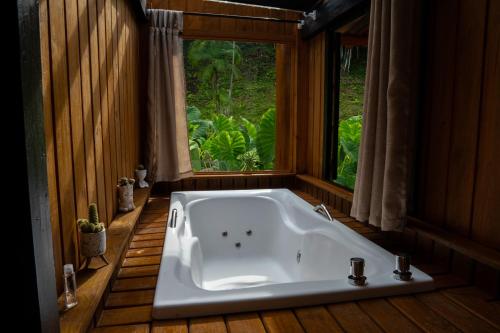 eine Badewanne im Bad mit Fenster in der Unterkunft Cabana Haere Tonu- Seu Refúgio no Coração do Vale Europeu in Benedito Novo