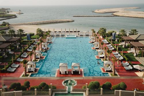 an aerial view of a resort pool and the beach at Royal Saray Resort in Manama
