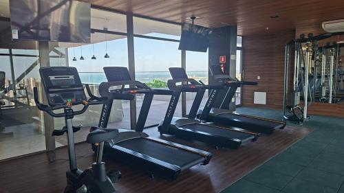 ein Fitnessstudio mit mehreren Cardiogeräten in einem Raum in der Unterkunft Vento Terral - 42m, Novo, Alto Padrão, Frente Mar in Fortaleza