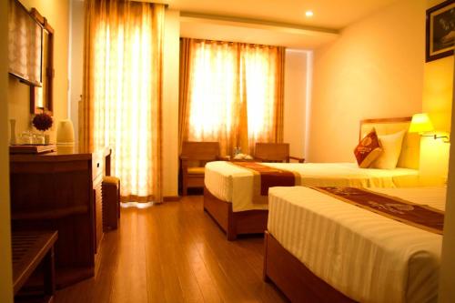 a hotel room with two beds and a window at Khách sạn Golden Beach Nha Trang in Nha Trang