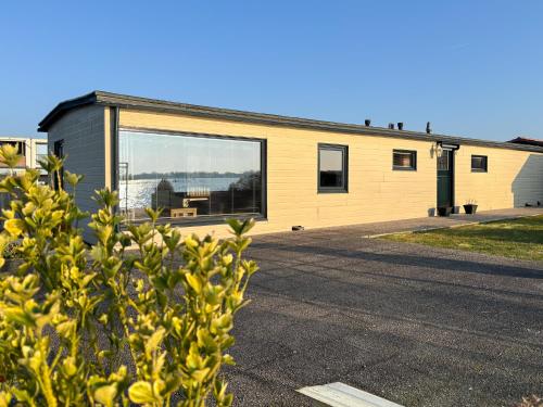 a yellow building with a large window at VISSERSLUST Rooms, Apartments and Houseboats in Vinkeveen
