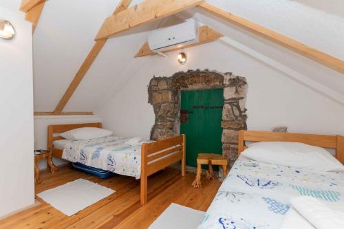 Cette chambre comprend 2 lits et une porte verte. dans l'établissement Villa Heritage Harmony with private pool, à Zmijavci