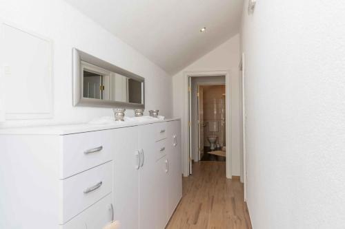 une salle de bain blanche avec un lavabo et un miroir dans l'établissement Villa Heritage Harmony with private pool, à Zmijavci