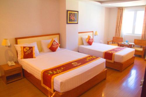a hotel room with two beds and a telephone at Khách sạn Golden Beach Nha Trang in Nha Trang