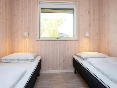 two beds in a room with a window at Luxury Beach House with Spa - By Traum Ferienwohnungen in Børkop