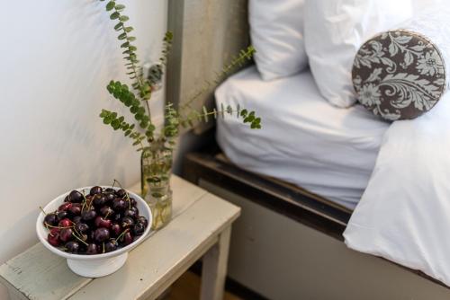 a bowl of fruit on a table next to a bed at Ein Zivan Village Resort in Ein Zivan