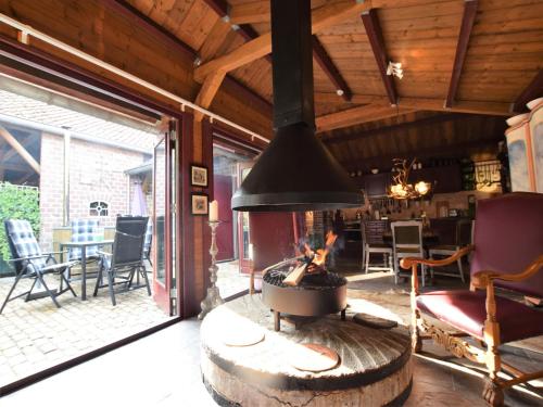 a fireplace in a living room with a table and chairs at Cottage near Bourtange with Hot Tub in Musselkanaal