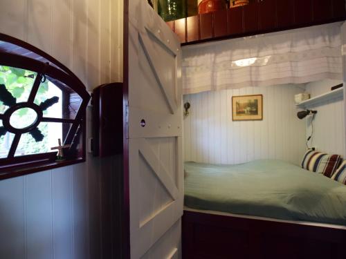 a small room with a bed and a window at Cottage near Bourtange with Hot Tub in Musselkanaal