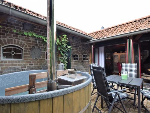 a patio with a table and chairs next to a building at Cottage near Bourtange with Hot Tub in Musselkanaal