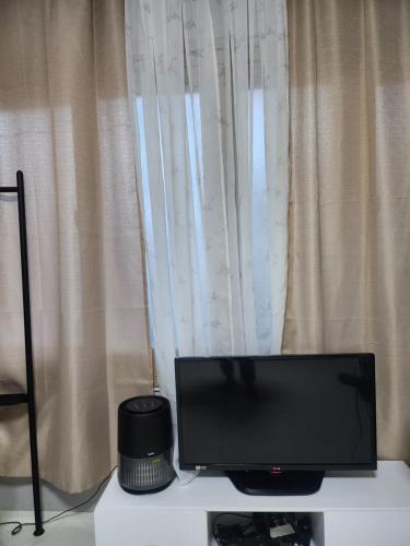 a television sitting on a table in front of a window at Lucky House in Busan