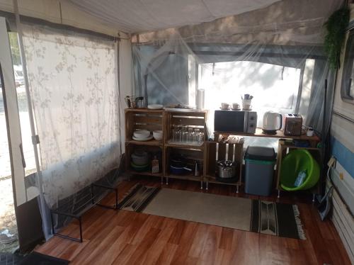 a room with a kitchen with a table and a window at Lakókocsi termál fürdő kemping in Túrkeve