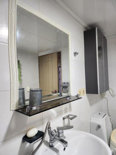 a bathroom with a sink and a mirror at Lucky House in Busan