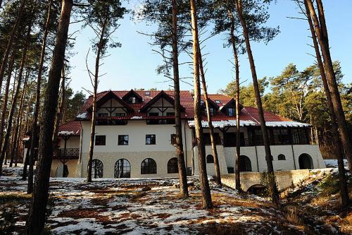 a large white house with a red roof at Hotel Kazimierski Zdrój in Janowiec
