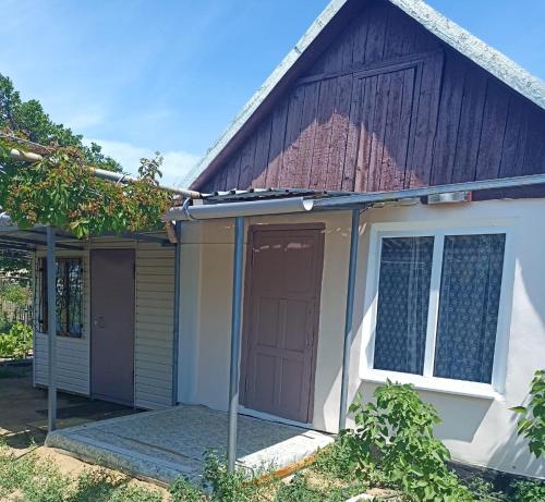 a house with a brown door and a garage at Дача на Балхаше недалеко от озера in Balqash