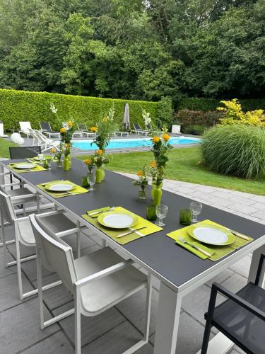 a gray table with yellow napkins and plates and chairs at Villa Tiffany in Braine-lʼAlleud