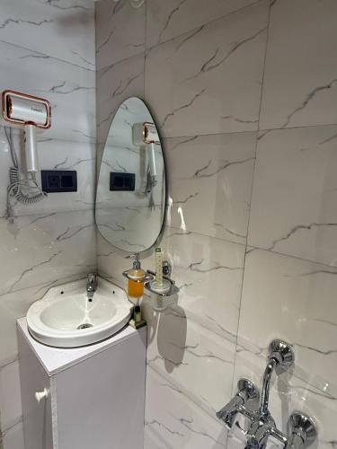 a white bathroom with a sink and a mirror at Ikigai 2Bhk Furnished Apartment Soothing Vibes in Navi Mumbai