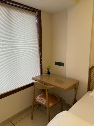 a bedroom with a desk and a window with a table at Ikigai 2Bhk Furnished Apartment Soothing Vibes in Navi Mumbai