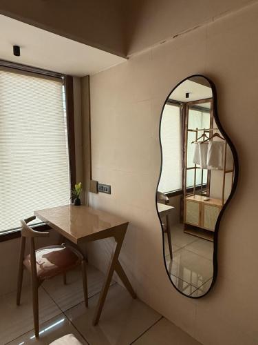 a mirror on the wall of a room with a table at Ikigai 2Bhk Furnished Apartment Soothing Vibes in Navi Mumbai