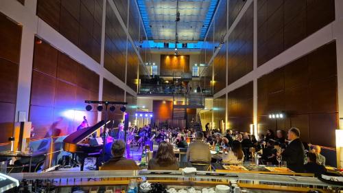 a group of people sitting at tables in a hall with a concert at DoubleTree by Hilton Turin Lingotto in Turin