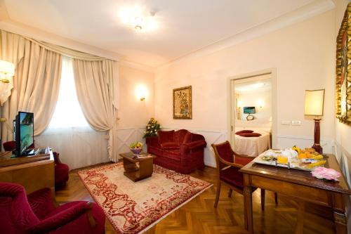 a living room with a red chair and a table at Zanhotel Centergross in Bentivoglio