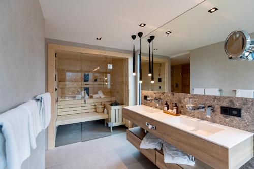 ein Badezimmer mit zwei Waschbecken und einem großen Spiegel in der Unterkunft Pfalzblick Wald Spa Resort in Dahn