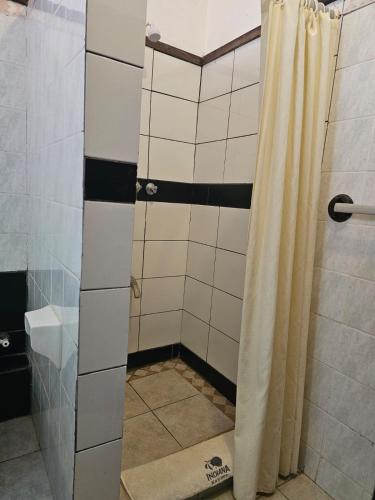 a shower with a shower curtain in a bathroom at Indiana Beach Apartments in Bamburi