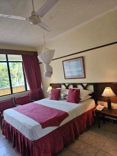 a bedroom with a large bed with pink pillows at Indiana Beach Apartments in Bamburi
