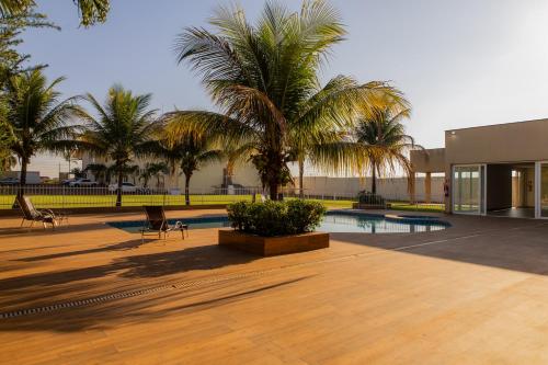 einen Innenhof mit Palmen und einem Pool in der Unterkunft Libertê Palace Hotel in Água Boa