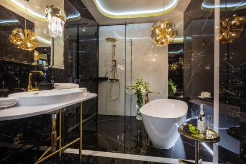 een badkamer met twee wastafels, een bad en een douche bij Feniks Fragola Apartments in Krakau