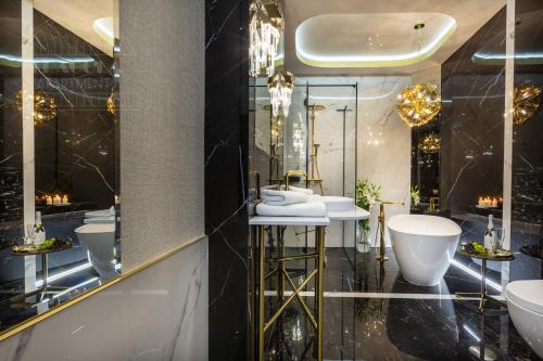 a bathroom with three sinks and two mirrors at Feniks Fragola Apartments in Kraków