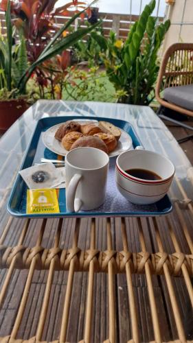 a tray with a plate of food and a cup of coffee at Vacances paisibles - petit déjeuner offert pour la première nuit in Saint-Paul