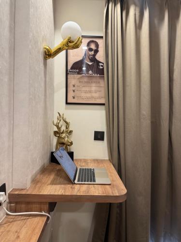 a laptop on a wooden table with a curtain at Hustle & Hyde in Lucknow
