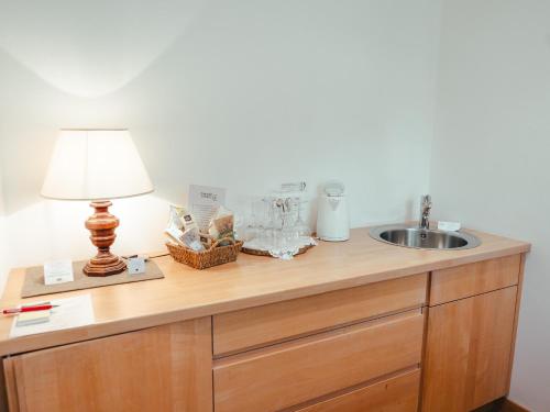 a bathroom counter with a sink and a lamp on it at Hotel Villa Freiheim in Merano