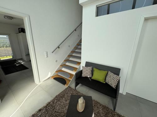 a living room with a staircase and a chair at Feine Auszeit in Gottmadingen